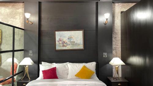 a bedroom with black walls and a bed with colorful pillows at Vathanagul Resort in Chiang Rai