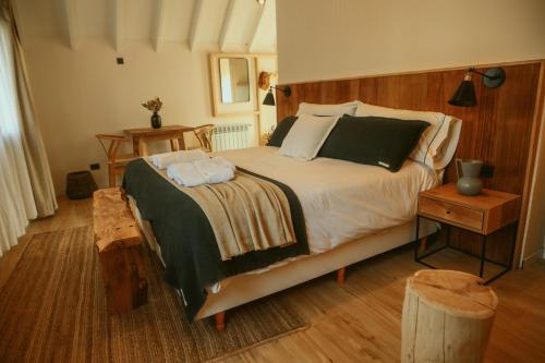 カリロにあるLa Galeria - Hotel Boutique Carilóの木製のヘッドボードが付いた大きなベッドのある寝室