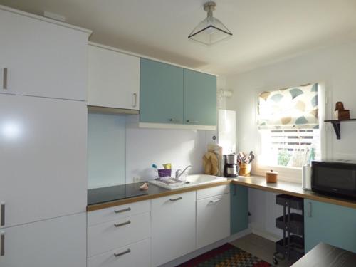 - une cuisine avec des placards bleus et blancs et un évier dans l'établissement Maison lumineuse 2 ch entre campagne et mer, proche golf et La Rochelle, parking et local vélo - FR-1-551-22, à Marsilly