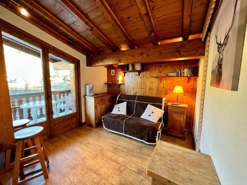 un salon avec un canapé en cuir et une fenêtre dans l'établissement Chaleureux studio au pied des pistes avec parking et animaux acceptés - FR-1-505-6, à Notre-Dame-de-Bellecombe