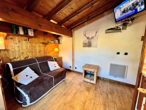 un salon avec un canapé et une télévision dans l'établissement Chaleureux studio au pied des pistes avec parking et animaux acceptés - FR-1-505-6, à Notre-Dame-de-Bellecombe