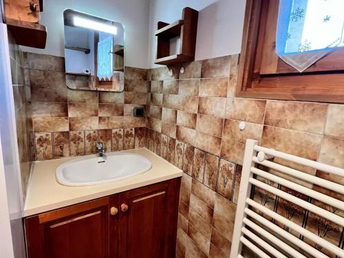 une salle de bain avec un lavabo et un miroir dans l'établissement Chaleureux studio au pied des pistes avec parking et animaux acceptés - FR-1-505-6, à Notre-Dame-de-Bellecombe