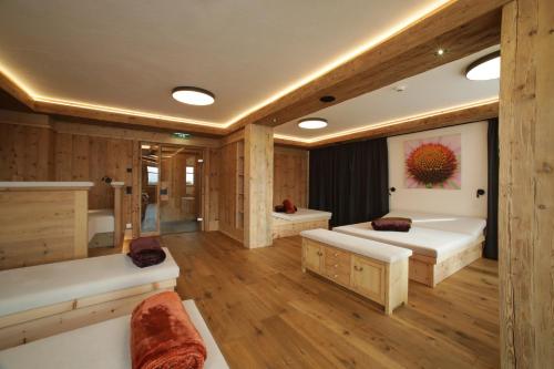 a large room with two beds and a shower at Hotel Gasthof Unterwöger in Obertilliach