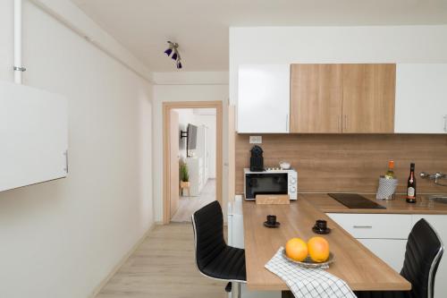 a kitchen with a table and chairs in a room at Stílusos lakás ingyenes parkolással in Debrecen
