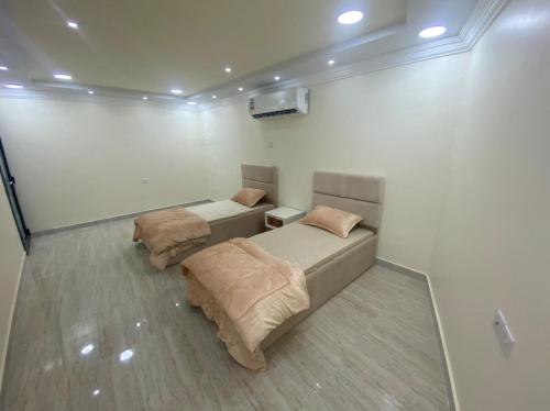 a bedroom with two beds in a room at Dar Al Hamra Rest إستراحة دار الحمراء in Al Ḩamrāʼ