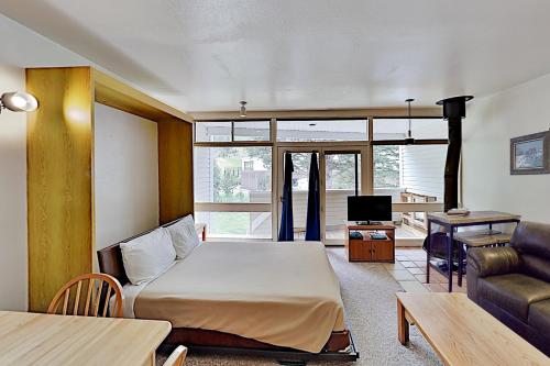 Habitación con cama, sofá y mesa. en Sierra Del Sol 5, en Taos Ski Valley