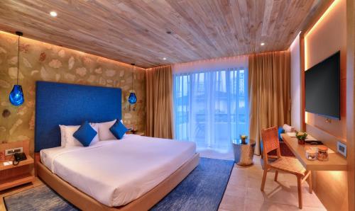 um quarto com uma cama, uma secretária e uma televisão em Hotel Barahi Pokhara em Pokhara