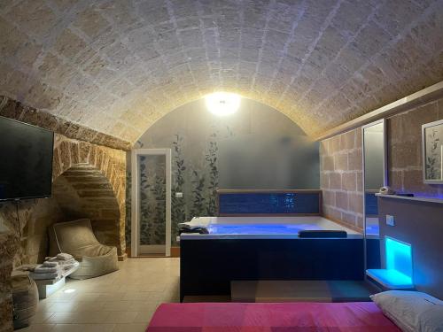 uma casa de banho com um quarto com uma cama e uma parede de pedra em Luxury Suite em Mesagne