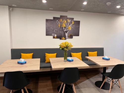 two tables with yellow pillows in a waiting room at Vertoni Hotel Yerevan in Yerevan