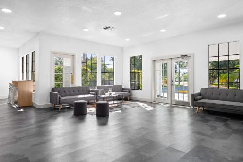 a large room with couches and tables and windows at Baymont by Wyndham Orlando Lake Buena Vista South in Kissimmee