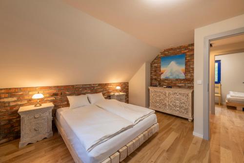 sypialnia z łóżkiem i ceglaną ścianą w obiekcie Winny Domek w Radochowie w mieście Lądek-Zdrój