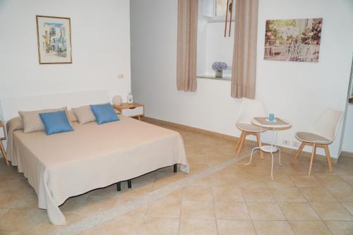 1 dormitorio con 1 cama, mesa y sillas en IL GLICINE en Sorrento