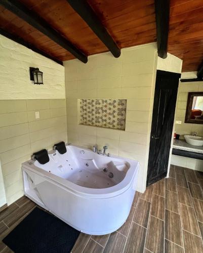 a large white tub in a bathroom with a sink at Estancia De La Campiña in Nono