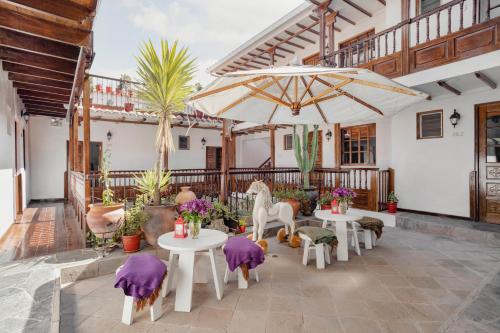 eine Terrasse mit Tischen, Stühlen und Sonnenschirmen in der Unterkunft Andenes in Cusco