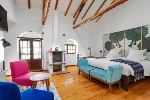 ein Schlafzimmer mit einem Bett, einem Sofa und einem Stuhl in der Unterkunft Andenes in Cusco