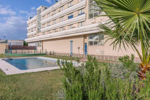 un edificio con piscina frente a un edificio en FIBES con parking gratis. Apartamento Sevilla Este. en Sevilla