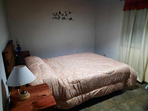 1 dormitorio con 1 cama y 1 mesa con lámpara en Mardifiore 3 en General Juan Madariaga