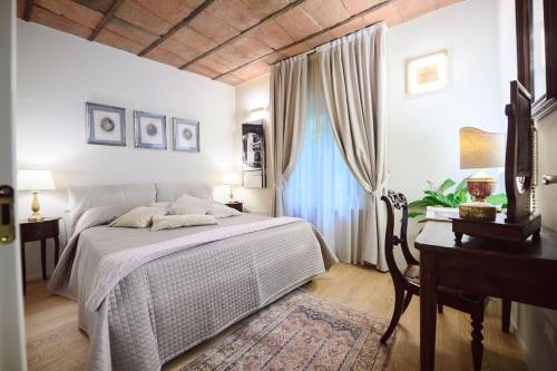 1 dormitorio con cama, escritorio y ventana en Corte Paolina - charming courtyard inside Lucca, en Lucca