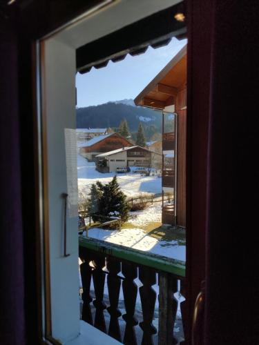 a view from a window of a balcony with snow at Spacious Ski Chalet In Traditional French Village, sleeps 8, Four Star with fibre broadband in Abondance