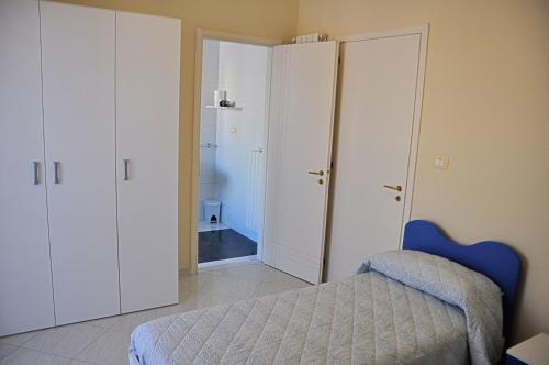 ein Schlafzimmer mit einem Bett und einer Tür zu einem Bad in der Unterkunft B&B Italia in Cerignola