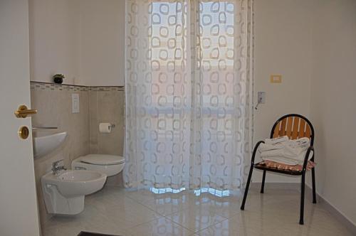 een badkamer met een toilet, een douche en een stoel bij B&B Italia in Cerignola
