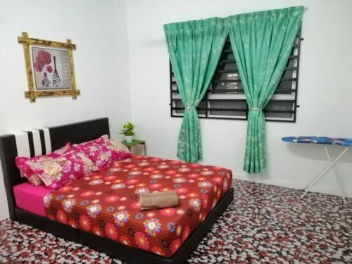 a bedroom with a bed and a window with green curtains at Seroja Residence Kuala Terengganu in Kuala Terengganu