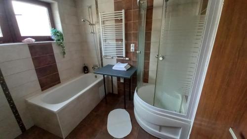 y baño con bañera, ducha y lavamanos. en Draga - 2 bedroom apartment, en Tržič