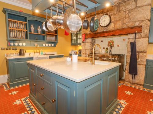 a large kitchen with blue cabinets and a sink at Plas Cerrig Hall, Crossways Road in Mold