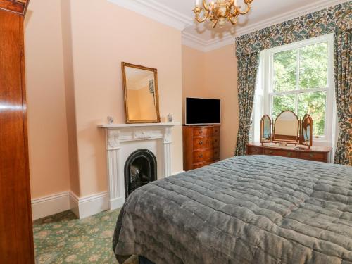 a bedroom with a bed and a fireplace at Plas Cerrig Hall, Crossways Road in Mold