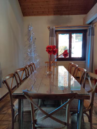a dining room table with chairs and a christmas tree at Spacious Ski Chalet In Traditional French Village, sleeps 8, Four Star with fibre broadband in Abondance