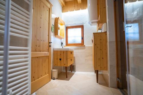 baño con armarios de madera y lavamanos en Chalet Zlatorog, en Bohinj
