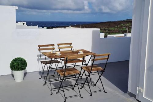 d'une table en bois et de quatre chaises sur un balcon. dans l'établissement Casa Mar y Lava, à El Golfo