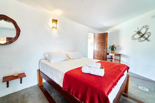 a bedroom with a bed with a red blanket at Pousada Bate Vento in Itarema