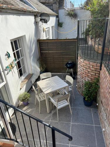 een patio met een tafel en stoelen op een balkon bij Bank Place in Falmouth