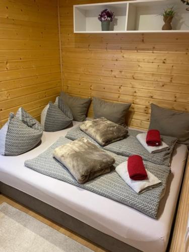 un letto con quattro cuscini e cappelli rossi sopra di Holiday Home Tettnang Walchesreute a Tettnang