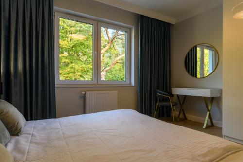 a bedroom with a large bed and a window at Double Rest in Jastrzębia Góra