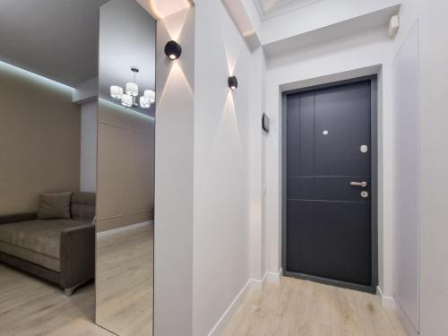 a hallway with a black door and a couch at Botanica, 1 bedroom apartment with living in Chişinău