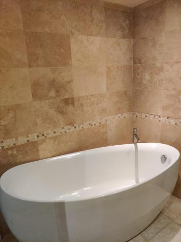 a white bath tub sitting in a bathroom at Spacious Ski Chalet In Traditional French Village, sleeps 8, Four Star with fibre broadband in Abondance