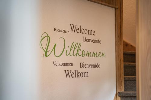 a sign on a wall with the words welcome welcome willuminati gmaxwell gmaxwell wisdom at Haus Sonnleitner in Ramsau am Dachstein