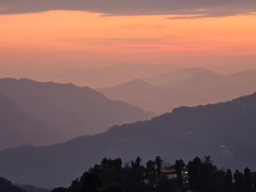 a view of a mountain range at sunset at The Sherpa's Abode in Gangtok