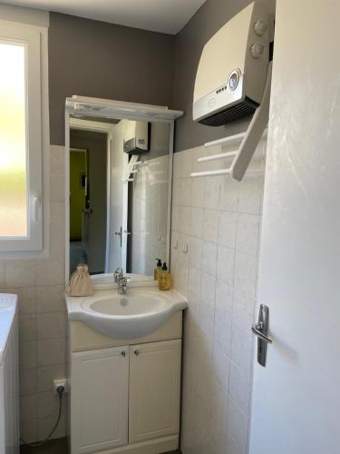 a bathroom with a sink and a mirror at BAIE MT ST MICHEL , JULLOUVILLE , VILLA Caprice Rdc , 50 m Mer ,7 pers , Prés Plage DDAY in Jullouville-les-Pins