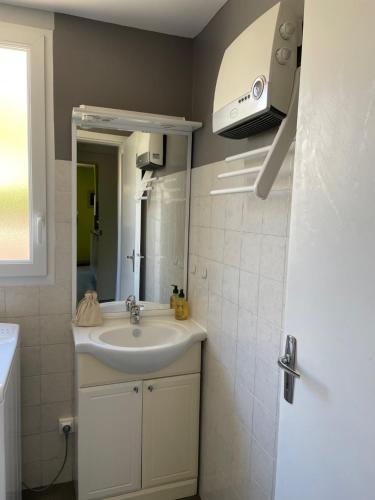 uma casa de banho com um lavatório e um espelho em BAIE MT ST MICHEL VILLA Caprice Rdc 50 m Mer Prés Plage DDAY 7pers em Jullouville-les-Pins