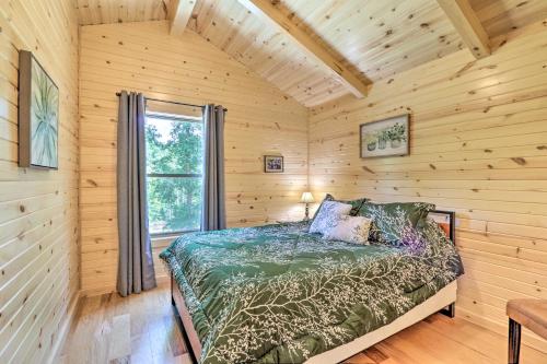 een slaapkamer met een bed in een blokhut bij Clover Cabin with Hot Tub and Deck in Hocking Hills! in Logan