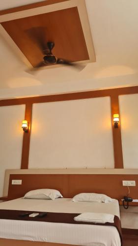 a bedroom with a bed with a large mirror above it at Hotel Exotica Squares in Neil Island