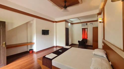 a bedroom with a bed and a chair in it at Hotel Exotica Squares in Neil Island