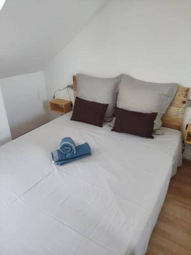a white bed with a blue shoe sitting on it at Superbe T3 en plein cœur du centre ville in Saint-Denis