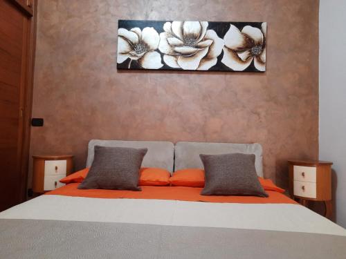 波佐利的住宿－MOONLIGHT HOUSE，一张带橙色枕头的床和墙上的绘画