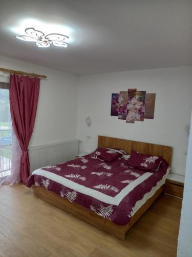 um quarto com uma cama com lençóis roxos e uma janela em Casa Daria 