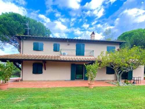 a white house with blue windows and a yard at La Casa di Agata Deluxe in Fucecchio