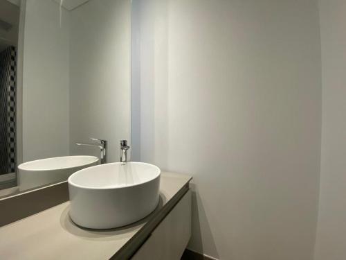 a bathroom with a large white sink and mirrors at Apartaestudio Amoblado - Distrito90 in Barranquilla